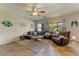 This living room includes tile flooring, a ceiling fan, and lots of natural light at 14554 W Evans Dr, Surprise, AZ 85379