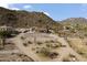 Aerial view of a Southwestern home featuring a horse arena, set against a scenic mountain backdrop at 1500 N Crismon Rd, Mesa, AZ 85207