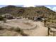 An aerial view showcases a home near a hillside, complete with a horse arena, blending living with nature at 1500 N Crismon Rd, Mesa, AZ 85207