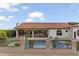Charming backyard showcasing a sparkling pool and outdoor dining area, framed by elegant landscaping and iron fencing at 1500 N Crismon Rd, Mesa, AZ 85207