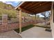 Covered patio area with stone wall, gravel, synthetic grass, and spiral staircase at 1500 N Crismon Rd, Mesa, AZ 85207