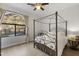 This primary bedroom features a beautiful four poster bed, wood floors and lovely outdoor views at 1500 N Crismon Rd, Mesa, AZ 85207