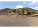 Spacious property with a white two-story home featuring a red tile roof, mature trees, and desert landscaping at 1500 N Crismon Rd, Mesa, AZ 85207