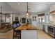 A gourmet kitchen features a wooden island, stainless steel appliances, and an open concept floor plan at 1500 N Crismon Rd, Mesa, AZ 85207