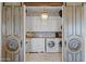 Laundry room features light cabinets, decorative backsplash, modern washer and dryer, and barn door entry at 1500 N Crismon Rd, Mesa, AZ 85207