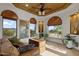 Bright living room features light wood floors, statement ceiling, and large windows with views of the desert landscape at 1500 N Crismon Rd, Mesa, AZ 85207