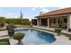 Inviting pool with lush landscaping, an outdoor fireplace, and elegant dining area, perfect for entertaining at 1500 N Crismon Rd, Mesa, AZ 85207