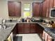 Kitchen with granite countertops, stainless steel appliances, and dark wood cabinetry at 16810 W Portland St, Goodyear, AZ 85338