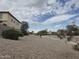 Desert landscaping on hillside with sidewalk and view of neighborhood beyond at 16810 W Portland St, Goodyear, AZ 85338