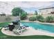 Resort style pool area features a spa, desert landscaping, string lights and lounge chair at 16810 W Portland St, Goodyear, AZ 85338