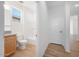 Well-lit bathroom with a tub/shower combo, wood-look tile flooring, and a single vanity at 18141 W Hiddenview Dr, Goodyear, AZ 85338