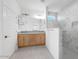 Modern bathroom with double vanity, marble shower, and neutral finishes at 18141 W Hiddenview Dr, Goodyear, AZ 85338