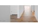 Bright hallway with wood floors and entry to a room at 18141 W Hiddenview Dr, Goodyear, AZ 85338