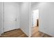 Bright hallway with wood floors and entry to a bathroom and entry door at 18141 W Hiddenview Dr, Goodyear, AZ 85338