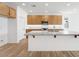 Bright, modern kitchen featuring a large island, stainless steel appliances, and wood-look tile flooring at 18141 W Hiddenview Dr, Goodyear, AZ 85338