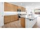 Well-lit kitchen showcasing stainless steel appliances, a large island, and access to the backyard at 18141 W Hiddenview Dr, Goodyear, AZ 85338