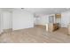 Open-concept living space with wood-look tile flooring flowing into the kitchen area at 18141 W Hiddenview Dr, Goodyear, AZ 85338