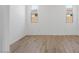Empty Room with wood floors, bright lighting and two windows at 18141 W Hiddenview Dr, Goodyear, AZ 85338