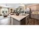 Modern kitchen with stainless steel appliances and island, open to living area and hardwood floor at 18848 N Barano Dr, Maricopa, AZ 85138