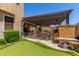 Picturesque backyard with a putting green, covered patio, and inviting seating area with fireplace at 1931 E Lantana Dr, Chandler, AZ 85286
