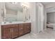 Bathroom featuring double sinks, wood cabinets, and a large mirror with modern lighting at 1931 E Lantana Dr, Chandler, AZ 85286
