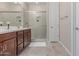 Bathroom featuring double sinks, wood cabinets, and a glass-enclosed shower at 1931 E Lantana Dr, Chandler, AZ 85286