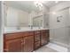 Bathroom featuring double sinks, wood cabinets, and a modern glass shower at 1931 E Lantana Dr, Chandler, AZ 85286
