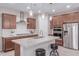 A kitchen with dark wood cabinets, stainless steel appliances, and a granite countertop island with seating at 1931 E Lantana Dr, Chandler, AZ 85286