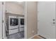 Bright laundry room featuring washer and dryer, shelving, tile flooring, and a doorway at 1931 E Lantana Dr, Chandler, AZ 85286
