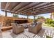 Inviting covered patio features a cozy fireplace, comfortable seating, and a well-manicured putting green at 1931 E Lantana Dr, Chandler, AZ 85286