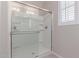 Shower featuring seamless glass doors, tiled walls, and modern fixtures at 1931 E Lantana Dr, Chandler, AZ 85286