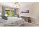 Bedroom with ceiling fan, large window, and neutral walls at 19700 N 76Th St # 2101, Scottsdale, AZ 85255