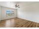 Bright bedroom with a ceiling fan, two windows, and wood flooring at 19700 N 76Th St # 2169, Scottsdale, AZ 85255