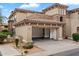 Charming two-story home featuring an open two-car garage, desert landscaping, and a decorative stone facade at 19700 N 76Th St # 2169, Scottsdale, AZ 85255