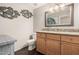 This bathroom has a marble counter, wooden cabinets, modern lighting, and a decorative fish art piece at 19777 N 76Th St # 1131, Scottsdale, AZ 85255