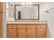 Bathroom with wood-look cabinets, a granite countertop, a large mirror, and chrome fixtures at 19777 N 76Th St # 1131, Scottsdale, AZ 85255