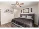 Comfortable bedroom with wood-look flooring, ceiling fan, and a gray upholstered headboard at 19777 N 76Th St # 1131, Scottsdale, AZ 85255