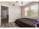 Bright bedroom features wood-look floors, a ceiling fan, and view into an adjacent office space at 19777 N 76Th St # 1131, Scottsdale, AZ 85255