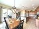 Dining area featuring a chandelier, a table set for six, and an open layout to the kitchen and patio doors at 20525 W Hamilton St, Buckeye, AZ 85396