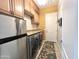 Modern laundry room with stainless steel appliances, wood cabinets, and stylish tile flooring at 20525 W Hamilton St, Buckeye, AZ 85396