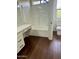 Bright bathroom featuring tile surround, white vanity with great lighting, and dark hardwood floors at 2074 N 109Th N Ave, Avondale, AZ 85392