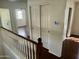 Upstairs hallway featuring neutral walls, dark hardwood floors, and white closet doors at 2074 N 109Th N Ave, Avondale, AZ 85392