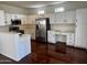 This bright kitchen features white cabinets, stainless steel appliances, and dark wood flooring at 2074 N 109Th N Ave, Avondale, AZ 85392