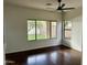 This living room features hardwood floors, white walls, and large windows providing backyard views at 2074 N 109Th N Ave, Avondale, AZ 85392