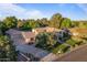 An aerial view of a lushly landscaped property and home with a long driveway and three-car garage at 2106 E La Vieve Ln, Tempe, AZ 85284