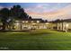Spacious backyard with a large lawn, covered patios, and beautifully lit exterior, perfect for entertaining at 2106 E La Vieve Ln, Tempe, AZ 85284