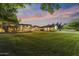 Sprawling backyard at dusk, with lush green grass and a patio area, perfect for outdoor entertaining at 2106 E La Vieve Ln, Tempe, AZ 85284