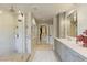Bathroom with double vanity, glass shower, and entryway into walk-in closet at 2106 E La Vieve Ln, Tempe, AZ 85284