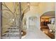 Grand foyer with ornate iron door, travertine floors, staircase and view to dining room at 2106 E La Vieve Ln, Tempe, AZ 85284
