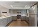 Well-lit kitchen featuring stainless steel appliances, gray cabinets, and sleek countertops at 2106 E La Vieve Ln, Tempe, AZ 85284
